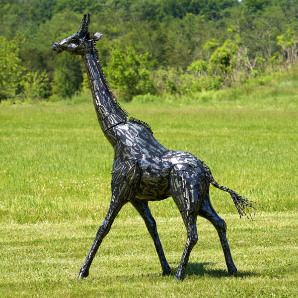 7 feet tall iron giraffe constructed from metallic black plates in gunmetal finish moving to the left