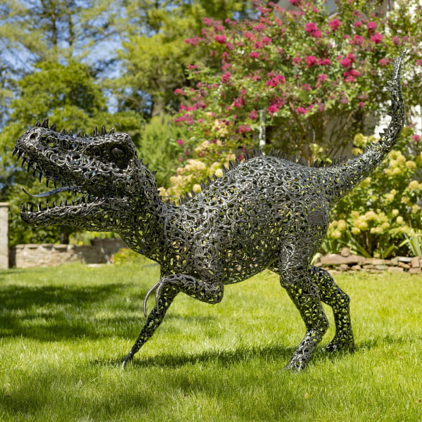 side view of 5.6 feet tall crouching Tyrannosaurus Rex metal sculpture with filigree details in metallic black-bronze distressed finish