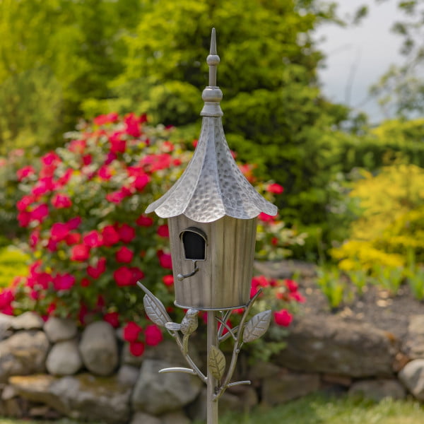 closed up image of iron cone roof birdhouse stake in antique silver hand-painted finish with little bird perched on decorative leaf
