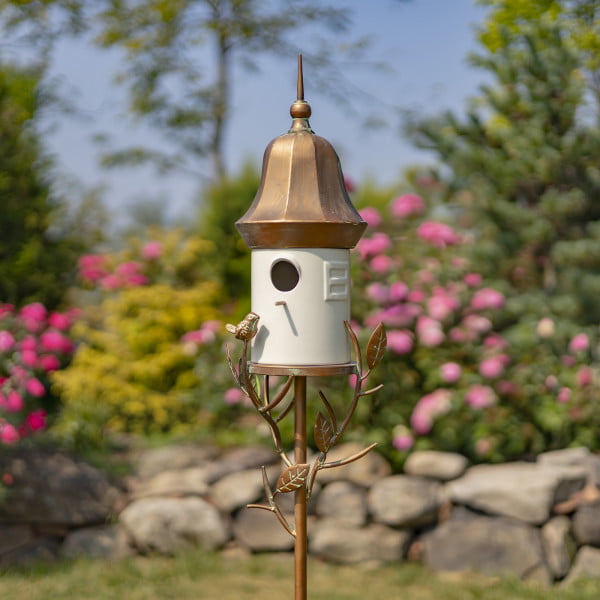 image of Iron and White porcelain birdhouse stake with bell roof and a little bird perched on leaves attached to the stake