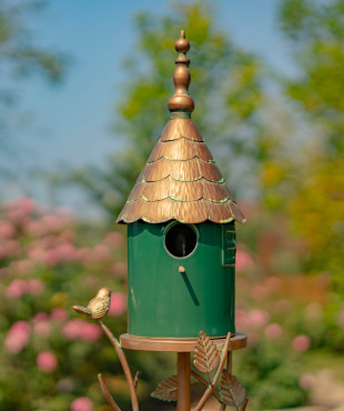 front view image of Iron and dark green porcelain birdhouse stake with cone roof and a little bird perched on leaves attached to the stake