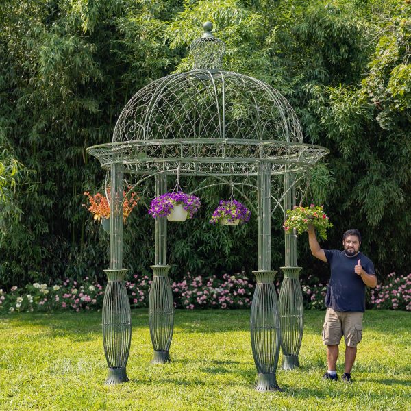 full size photo of 13 feet tall round metal garden gazebo in antique green distressed finish decorated with hanging flower pots in backyard, gentleman is standing near it