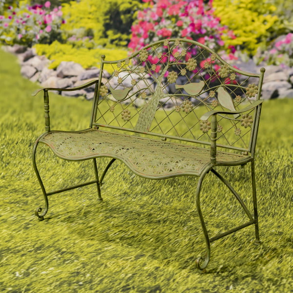 classic iron garden bench with blooming tree and birds on lattice backrest in distressed antique rust-green finish