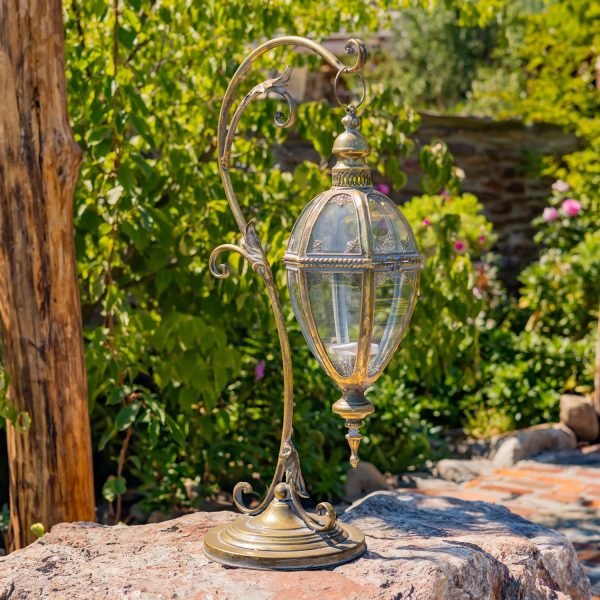 31 Tall Victorian-Style Hanging Lantern with Ornate Iron Stand in Gold finish standing in garden