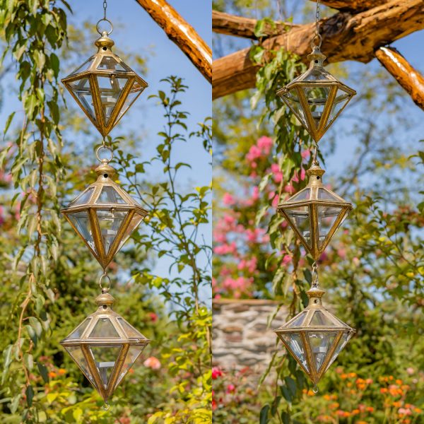 2 iron and glass hanging diamond-shape lantern chains in frosted gold finish hanging in garden