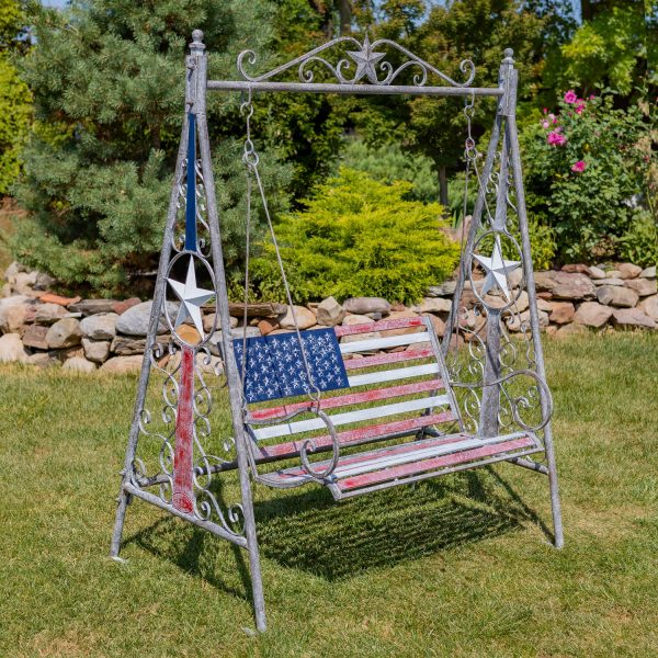 72 inch tall iron swing bench in American Flag style standing in beautiful garden