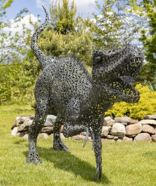 front view of 7.3feet tall crouching Tyrannosaurus Rex metal sculpture with filigree details in metallic black-bronze distressed finish