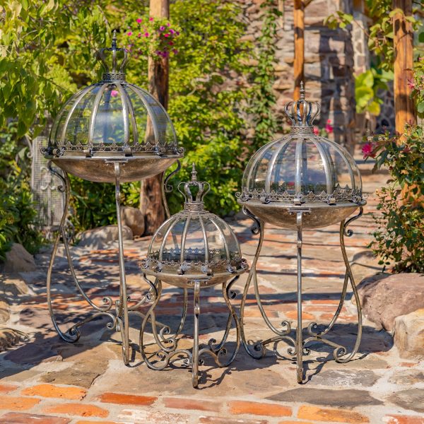 Set of 3 glass dome terrariums in 3 sized hand painted in frosted silver finish standing in garden