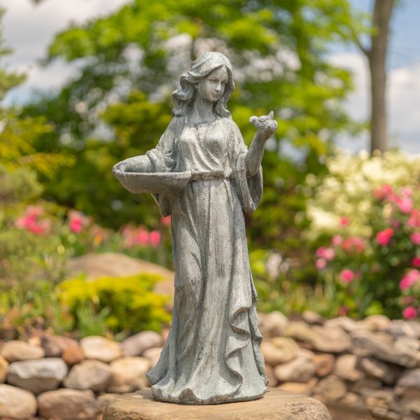 Tall girl magnesium garden statue in a grey stone finish color admiring a bird she is holding in one hand while holding a bowl in the other