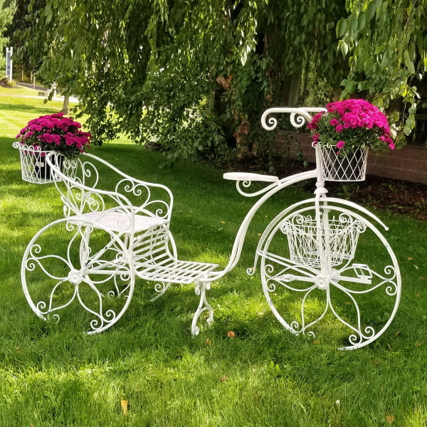 Large iron tricycle plant stand with flower baskets in antique white in garden