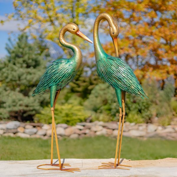 Pair of 41 inches tall metal heron garden figurines in metallic finish, in fall garden