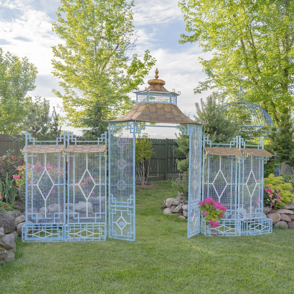 16 feet long iron garden gate in soft blue and white colors with four side planters in Asian pagoda style with gold roof in garden