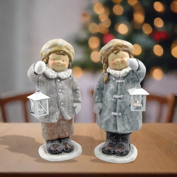 Pair of boy and girl standing in winter outfits holding lanterns Christmas statuary