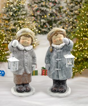 Pair of boy and girl standing in winter outfits holding lanterns Christmas statuary