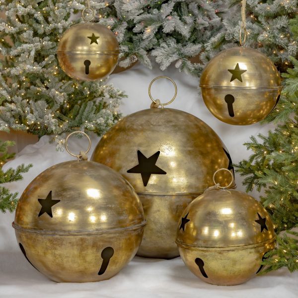 Set of 5 large sleigh bells with star cutouts in antique gold finish, 3 standing on faux snow and 2 hanging on rope