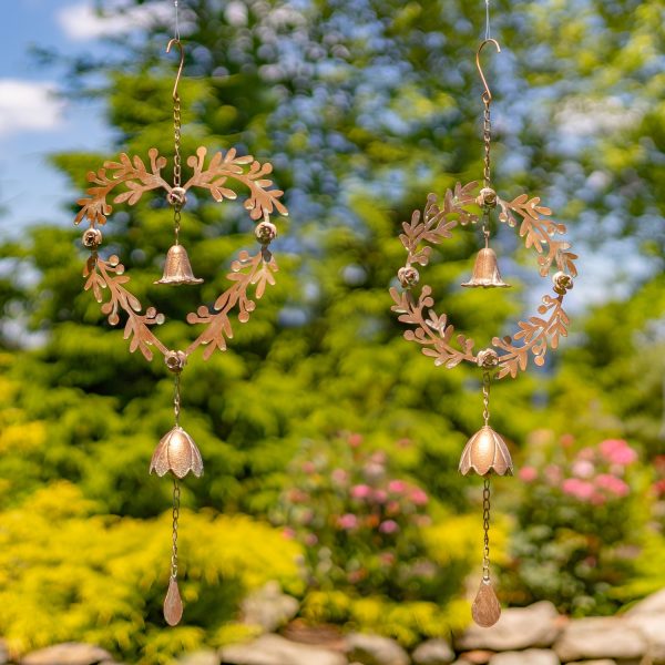 hanging iron round and heart wreaths with dangling lily bells in antique copper finish, in garden