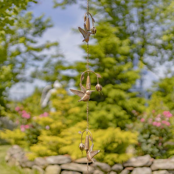 extra long iron rain chain featuring hummingbird and flower with bell in antique copper finish hanging in garden