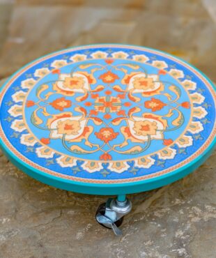 Flat round plant trolley with mosaic tiling in colors teal and orange
