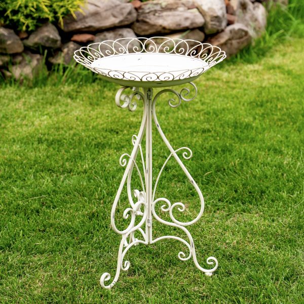 image of antique white metal birdbath with round basin with embellished wire perimeter and folding stand