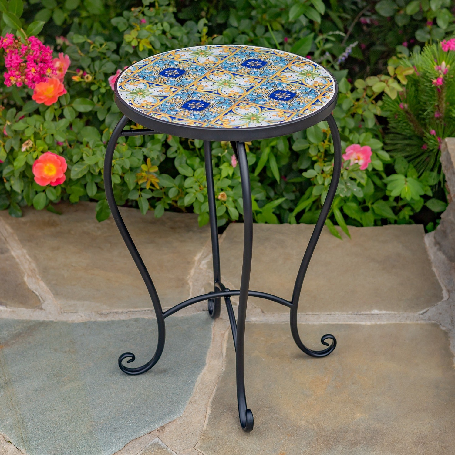 Bar Harbor Pedestal Plant Stand features a round top with checkerboard design and floral accents, attached to a sturdy matte black metal frame.