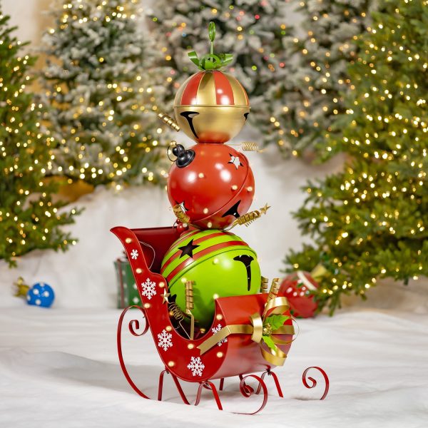 This is a tall metal Christmas decoration made of big bells stacked in a tower. It’s almost as tall as a person and feels smooth and cool. The shape is narrow and gets smaller at the top, like a cone. It feels strong and is used to decorate for the holidays.