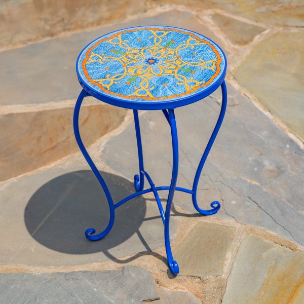 The Naples Pedestal Plant Stand features a predominantly blue ceramic tiles with gold, red, and green accents, attached to a sturdy blue metal frame.